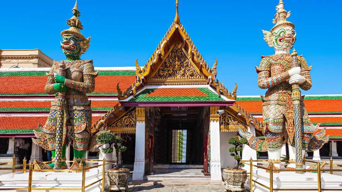 Eingang zum Wat Phra Kaew Tempel in Bangkok mit imposanten Wächterstatuen
