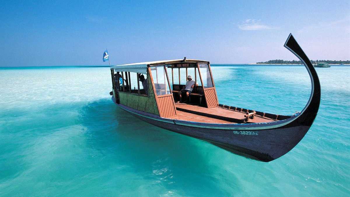 Traditionelles Dhoni-Boot auf den Malediven über türkisfarbenem Wasser