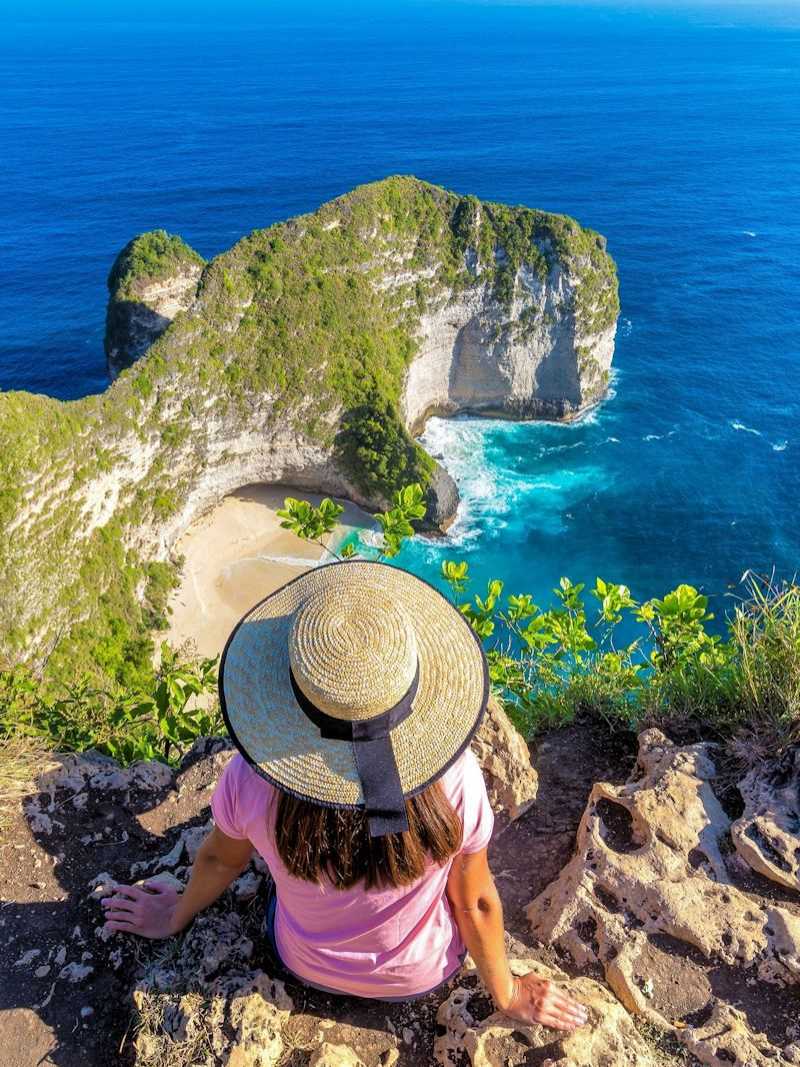 Reiseideen entdecken: Reisende mit Blick auf die Steilküste und den Kelingking Beach auf Nusa Penida