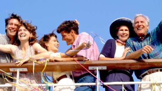Fröhliche Gruppe von Reisenden auf dem Deck eines Kreuzfahrtschiffs, umgeben von Luftschlangen und blauem Himmel – perfekte Stimmung für eine Minikreuzfahrt.