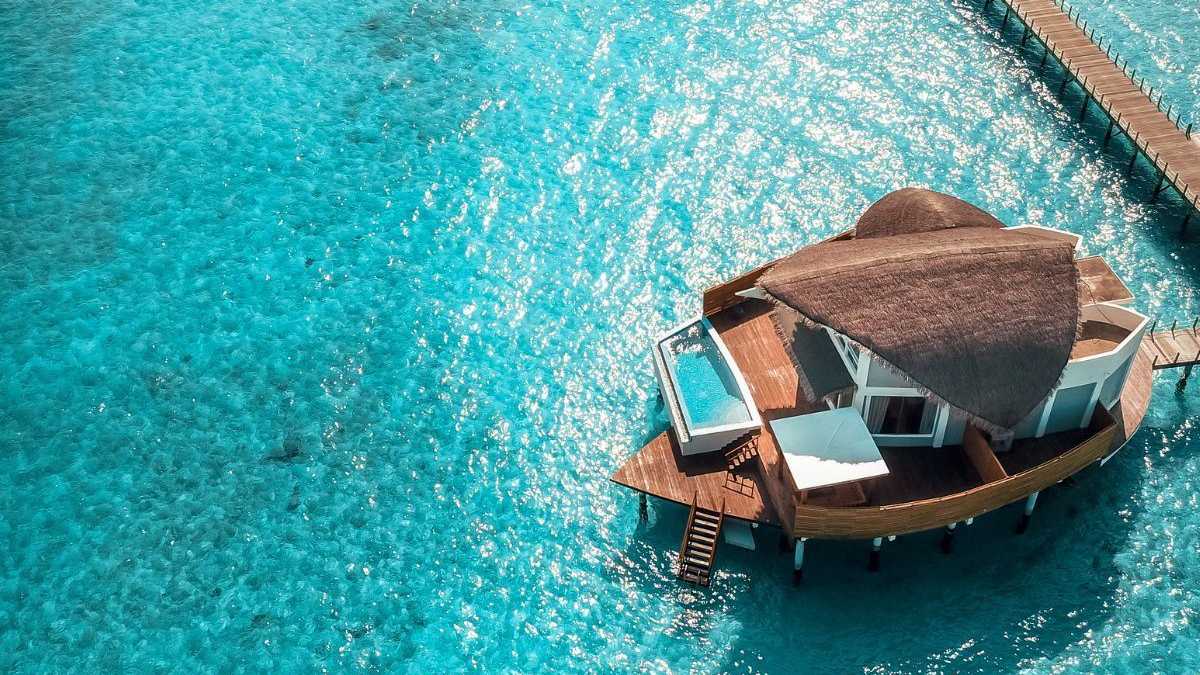 Luxuriöse Water Villa mit privatem Pool über türkisfarbenem Wasser auf den Malediven